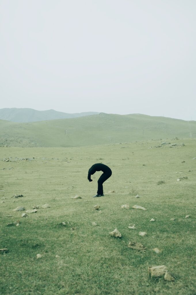 A person standing in a field with rocks