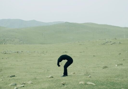 A person standing in a field with rocks