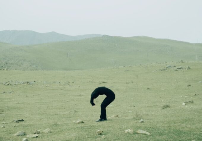 A person standing in a field with rocks