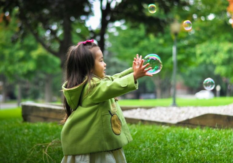 selective photo of a girl holding bubbles